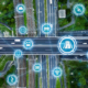 Vogelperspektive auf Autobahnkreuzung. Darüber Netzstruktur mit Icons zum Thema Verkehr.